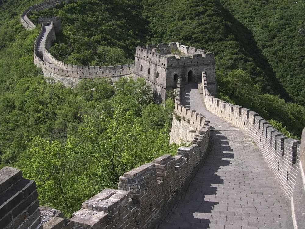 The Great Wall of China winding along a forested ridge